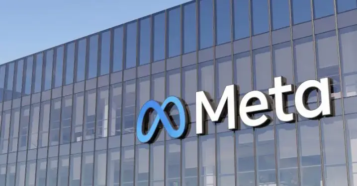 Fachada de edificio de cristal con el logotipo corporativo de Meta y su símbolo en azul.