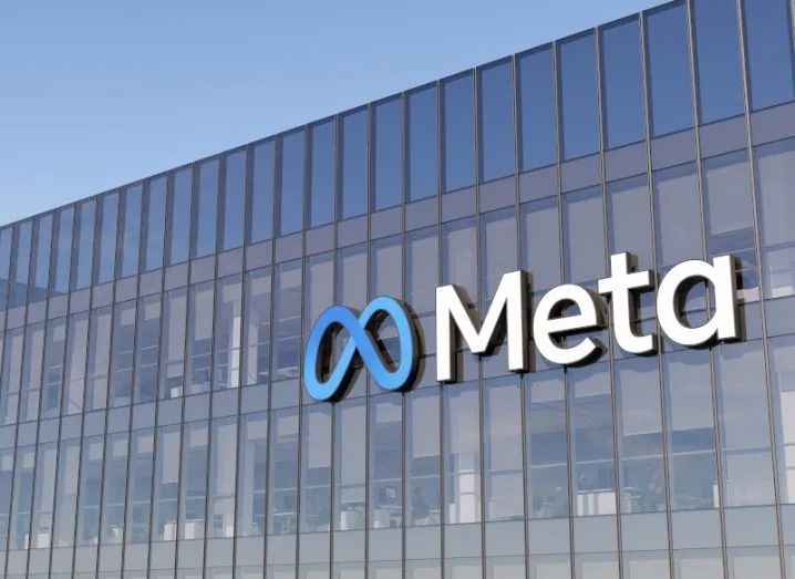 Fachada de edificio de cristal con el logotipo corporativo de Meta y su símbolo en azul.