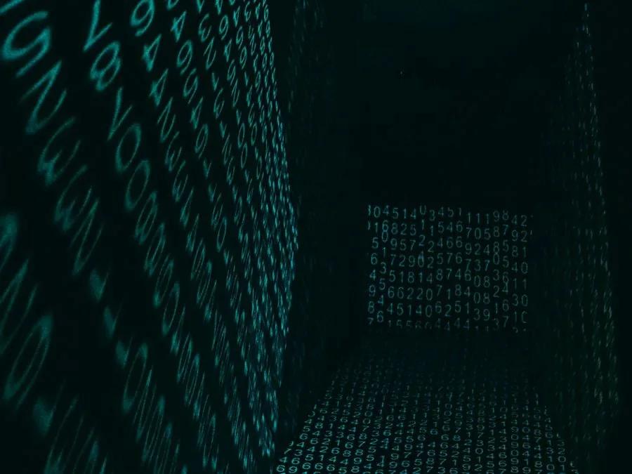 Espacio digital tridimensional con paredes y suelo formados por números brillantes en tono verde azulado sobre fondo negro.