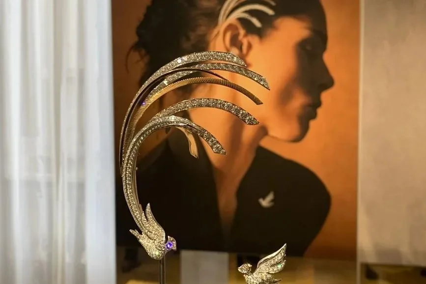 Pieza de joyería lujosa con incrustaciones de brillantes en primer plano y un retrato borroso al fondo.