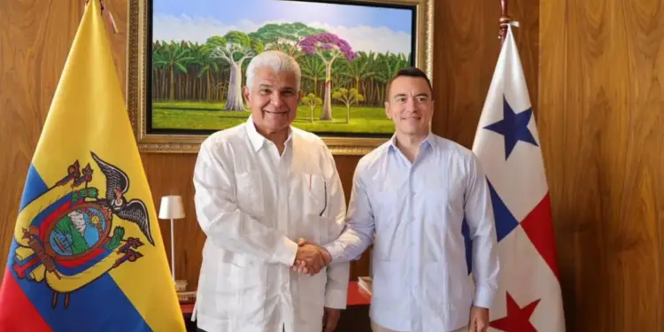 Dos hombres sonrientes estrechan manos frente a las banderas de Ecuador y Panamá, simbolizando un acuerdo o colaboración.
