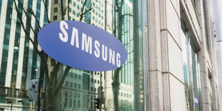 Logotipo ovalado de color azul con la marca Samsung en la fachada de cristal de un edificio corporativo.