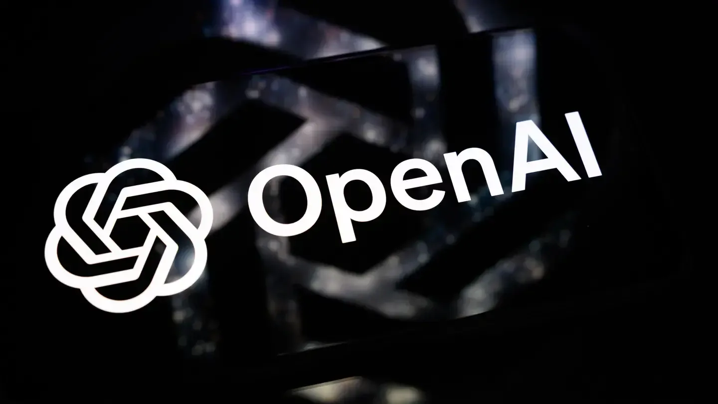 Logo blanco de OpenAI con su icono gráfico sobre una pantalla en un fondo oscuro.