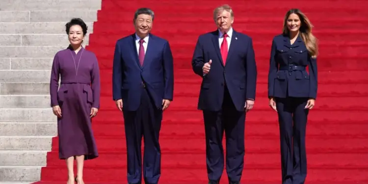 Cuatro personas de pie sobre una alfombra roja en una escalinata monumental durante una visita diplomática oficial.