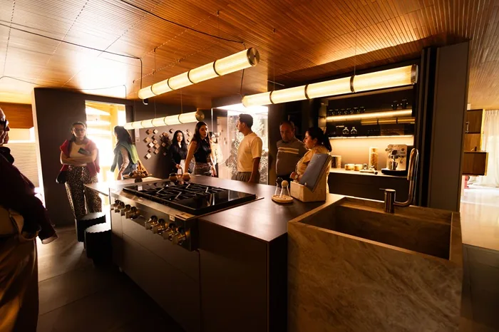 Grupo de personas reunidas en una cocina moderna durante un evento de negocios o presentación profesional.