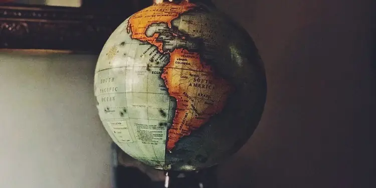 Globo terráqueo antiguo enfocado en el continente americano y el océano Pacífico con tonos oscuros.