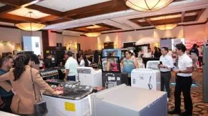 Asistentes observando electrodomésticos en una feria comercial en un salón amplio