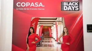 Dos modelos con vestidos rojos posan en la entrada de la feria Copasa Black Days en un evento comercial.
