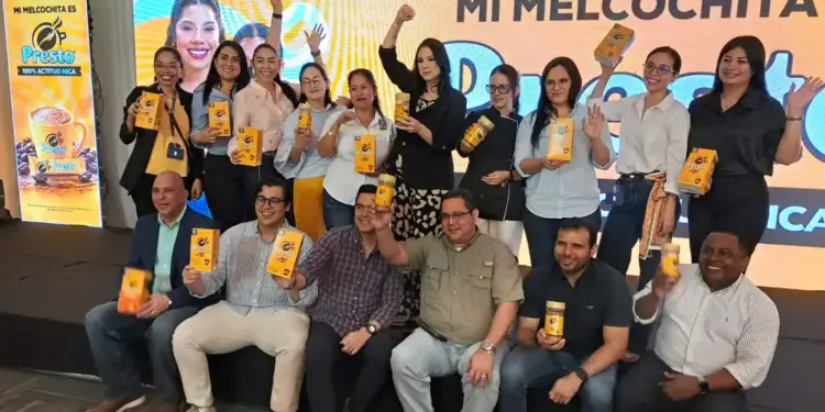 Equipo de Nestlé y Café Presto posa con frascos de Presto frente a una pantalla con el lema Mi Melcochita