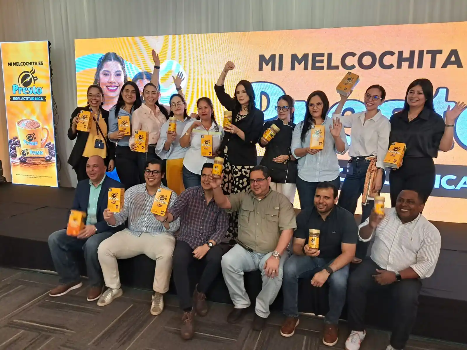 Equipo de Nestlé y Café Presto posa con frascos de Presto frente a una pantalla con el lema Mi Melcochita