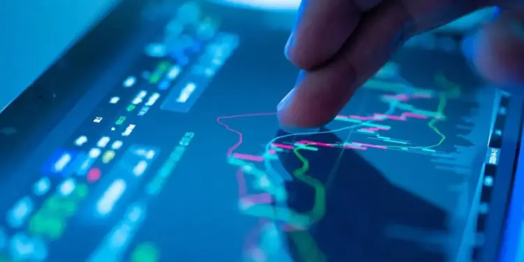 Primer plano de un dedo interactuando con gráficos financieros y datos en una pantalla digital, mostrando análisis de mercado y tendencias económicas.