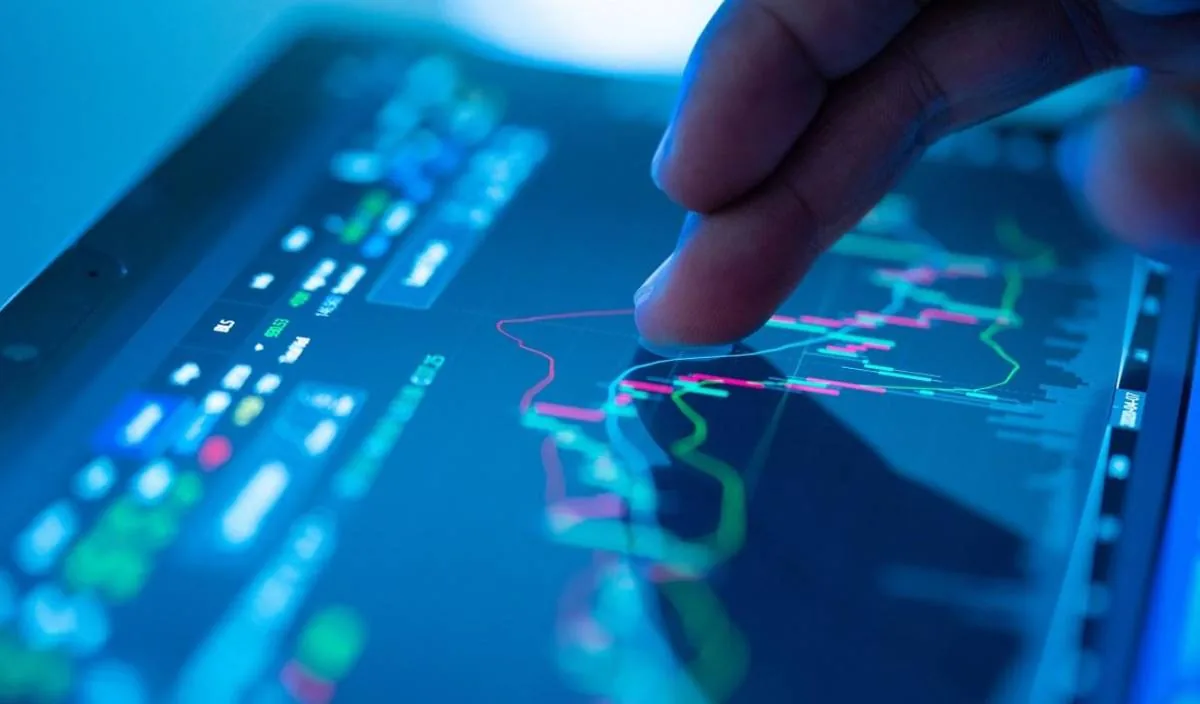Primer plano de un dedo interactuando con gráficos financieros y datos en una pantalla digital, mostrando análisis de mercado y tendencias económicas.