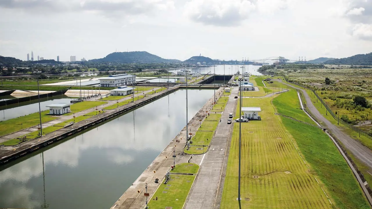 Vista aérea de un sistema de esclusas y un canal de navegación con áreas verdes y edificios administrativos.