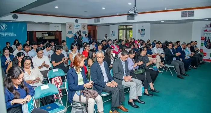 Audiencia sentada en un auditorio durante un evento profesional de negocios y finanzas.