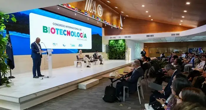 Conferencista hablando en el atril durante el Congreso Internacional de Biotecnología frente a una audiencia sentada.