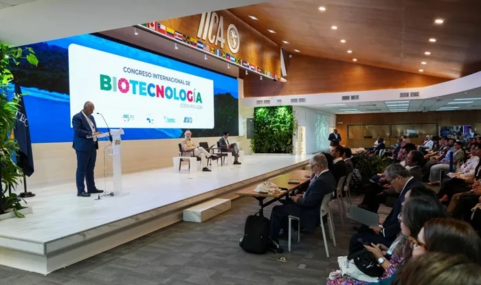 Conferencista hablando en el atril durante el Congreso Internacional de Biotecnología frente a una audiencia sentada.