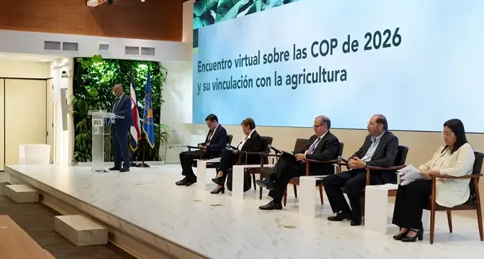 Panel de ponentes sentados en un escenario frente a una gran pantalla con texto sobre agricultura y las COP de 2026.
