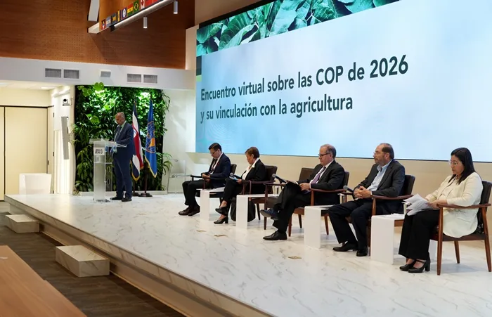 Panel de ponentes sentados en un escenario frente a una gran pantalla con texto sobre agricultura y las COP de 2026.