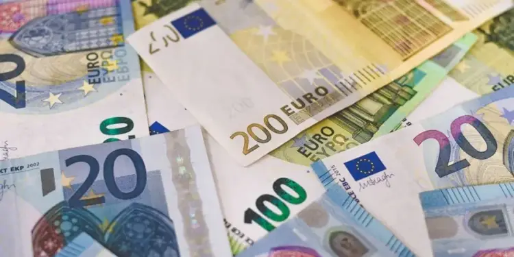 Primer plano de varios billetes de euro esparcidos, incluyendo denominaciones de 20, 100 y 200 euros, simbolizando finanzas y economía.