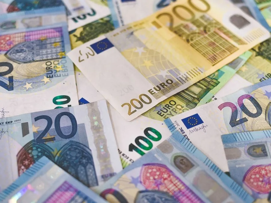 Primer plano de varios billetes de euro esparcidos, incluyendo denominaciones de 20, 100 y 200 euros, simbolizando finanzas y economía.