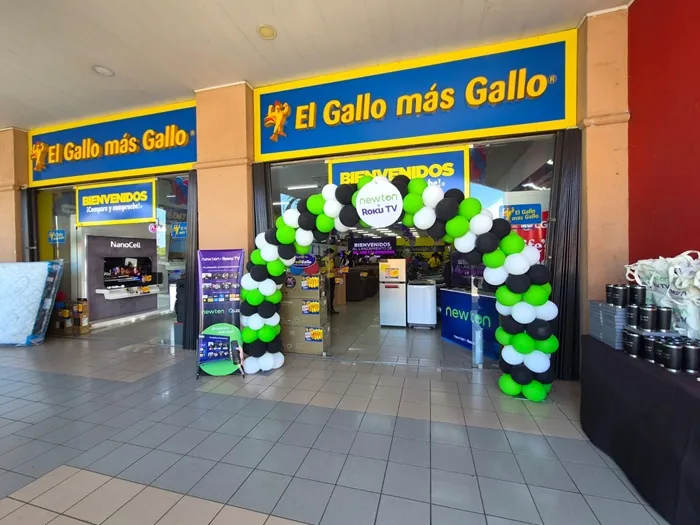 Fachada de la tienda El Gallo más Gallo con un arco de globos blancos, negros y verdes en la entrada principal.