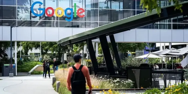 Vista exterior del edificio con el logotipo de Google y personas caminando por el campus.