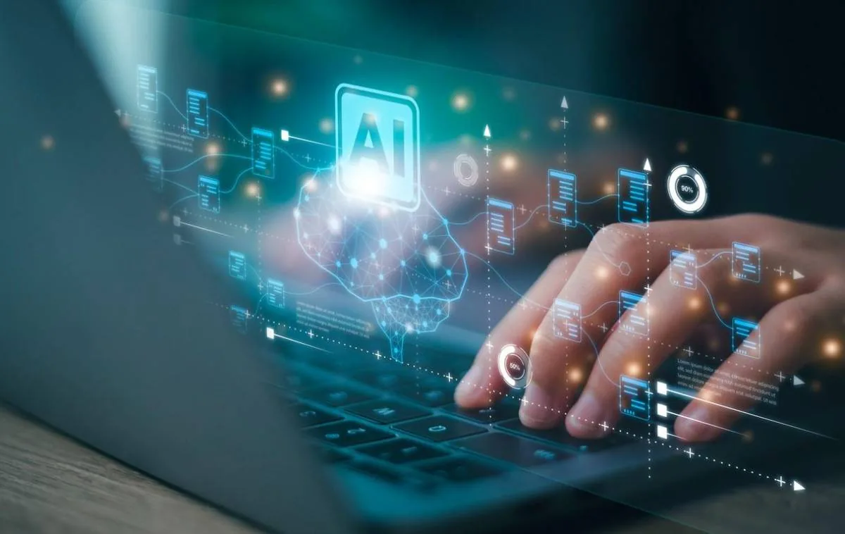 Manos escribiendo en un portátil con una interfaz digital holográfica superpuesta de inteligencia artificial.