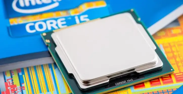 Procesador de computadora Intel Core i5 metálico sobre un fondo con patrón de oblea de silicio y empaque azul.