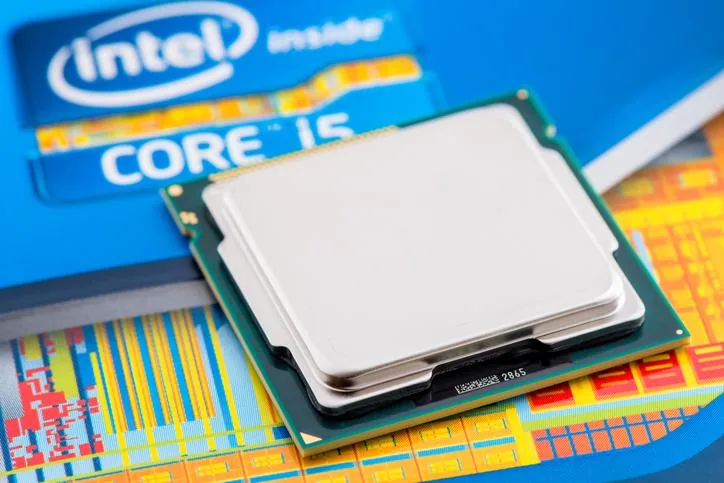 Procesador de computadora Intel Core i5 metálico sobre un fondo con patrón de oblea de silicio y empaque azul.