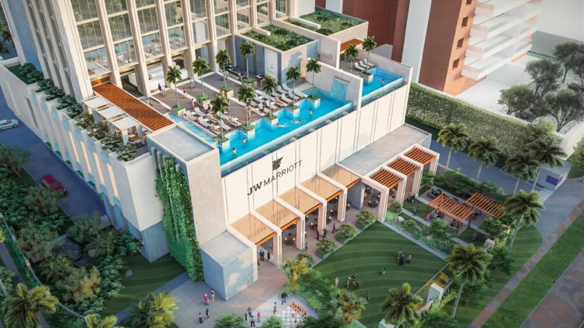 Vista aérea de un moderno hotel JW Marriott con piscinas en la azotea, jardines verticales y una entrada principal con pérgolas. Personas disfrutan de las instalaciones y áreas verdes.