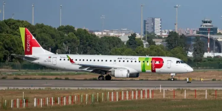 Avión comercial blanco y rojo con la marca AIR PORTUGAL rodando por la pista de un aeropuerto durante el día.