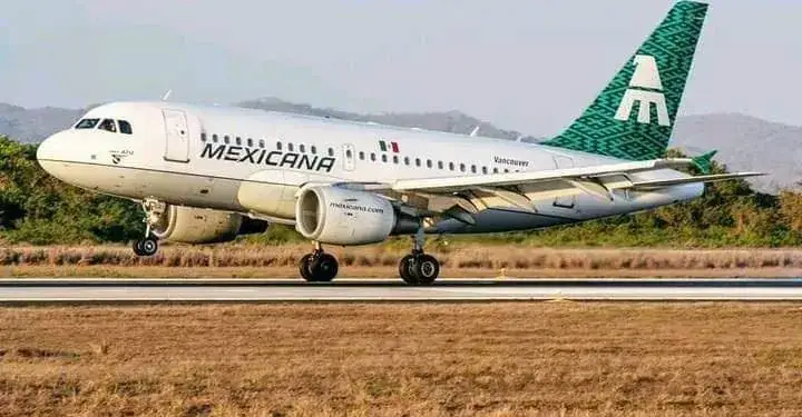 Avión comercial de la aerolínea Mexicana de aviación aterrizando en una pista rodeada de vegetación y montañas.