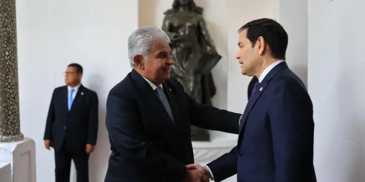Dos hombres con traje formal estrechando las manos en un evento oficial de negocios.