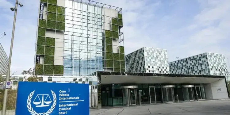 Edificio moderno con fachada de cristal y jardines verticales, señalización de la Corte Penal Internacional visible en primer plano.
