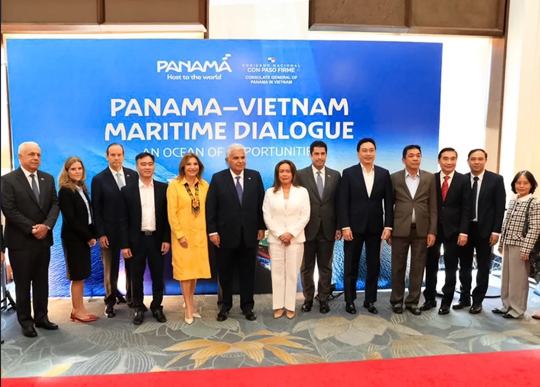 Grupo de personas posando frente a un panel azul que dice Panamá-Vietnam Maritime Dialogue.