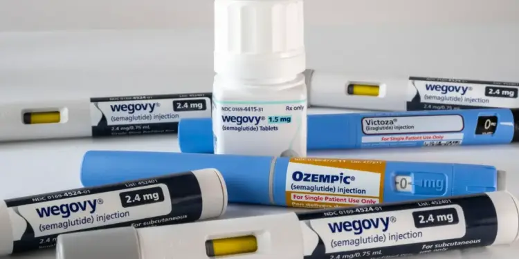 Dispositivos de inyección y pastillas de Wegovy, Ozempic y Victoza sobre una superficie blanca.