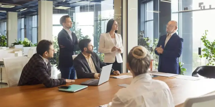 Grupo de profesionales en una reunión de negocios alrededor de una mesa de madera en una oficina moderna