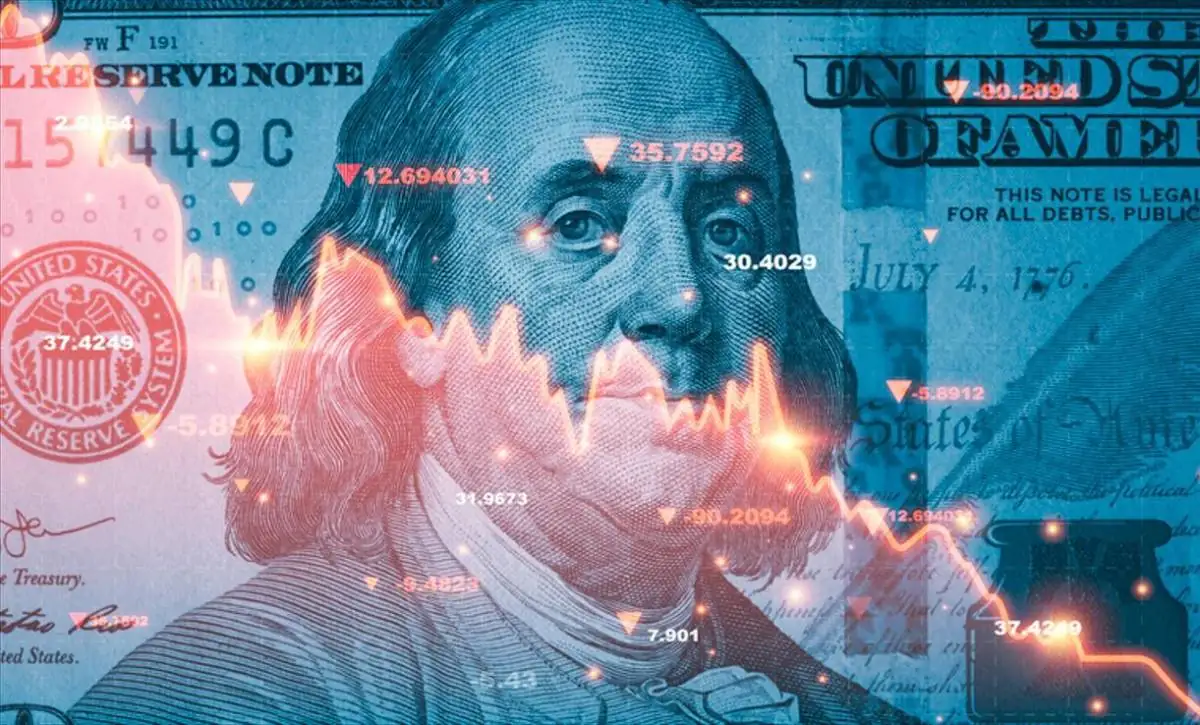 Primer plano de un billete de cien dólares con tonos azules y gráficos de caída en color rojo superpuestos.