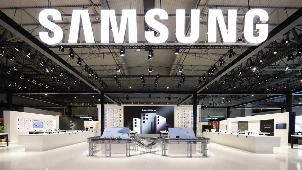Gran letrero iluminado de la marca Samsung sobre un stand comercial en una feria tecnológica.