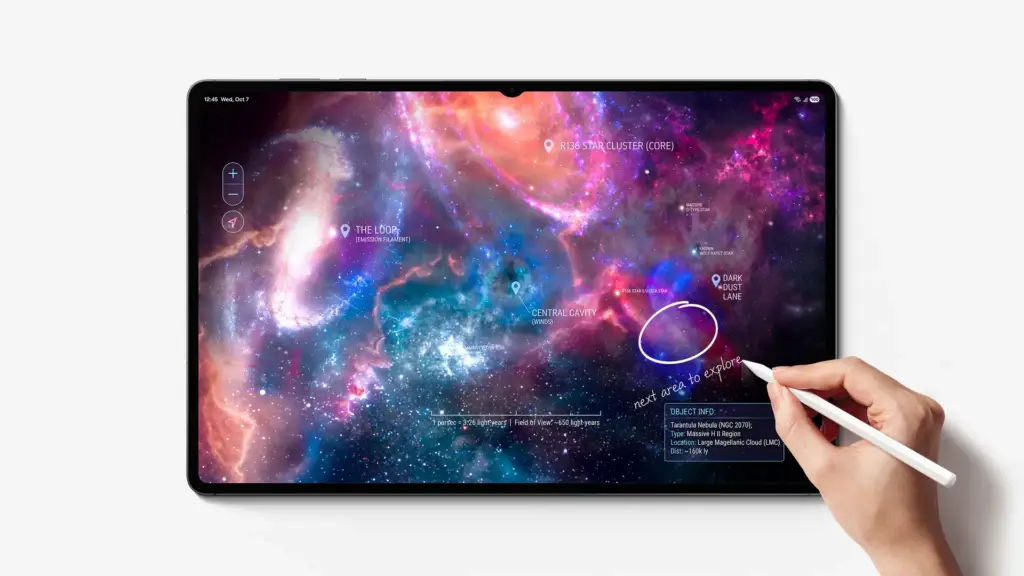 Mano usando un lápiz óptico en una tablet que muestra una galaxia con etiquetas astronómicas sobre un fondo blanco.