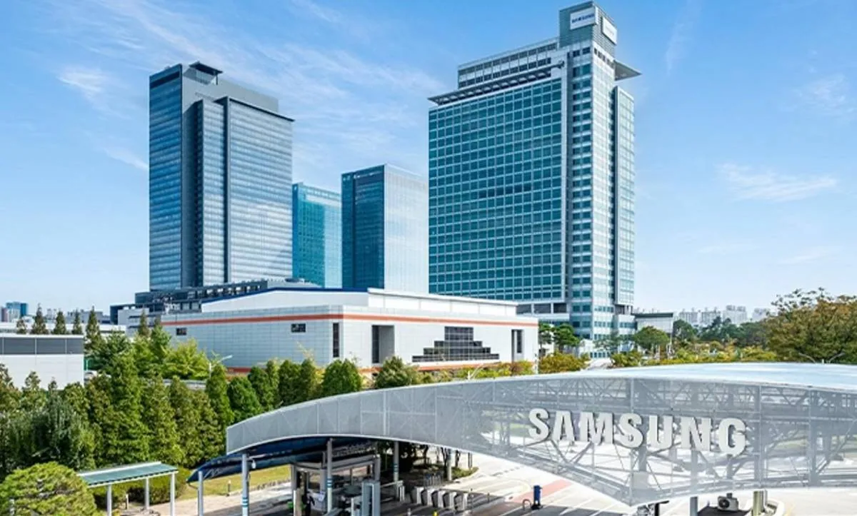 Complejo de edificios corporativos de Samsung con rascacielos de cristal, áreas verdes y señalización de la marca bajo un cielo azul.
