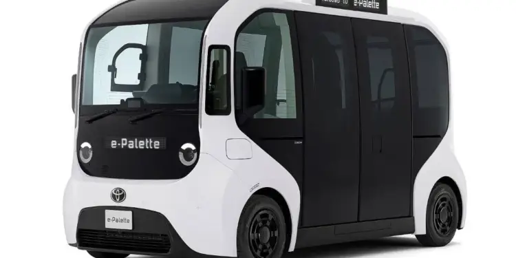 Vehículo eléctrico y autónomo blanco con diseño futurista y puertas correderas negras, mostrado sobre fondo blanco.