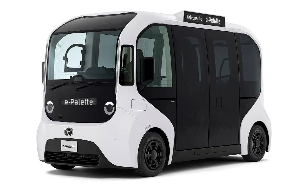 Vehículo eléctrico y autónomo blanco con diseño futurista y puertas correderas negras, mostrado sobre fondo blanco.