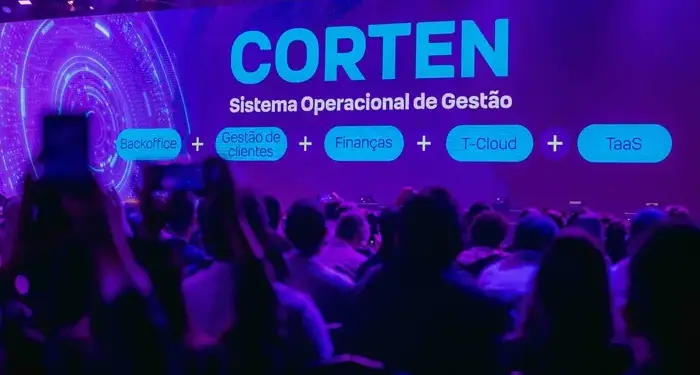 Público en un auditorio oscuro viendo una gran pantalla digital con la palabra CORTEN y servicios financieros.