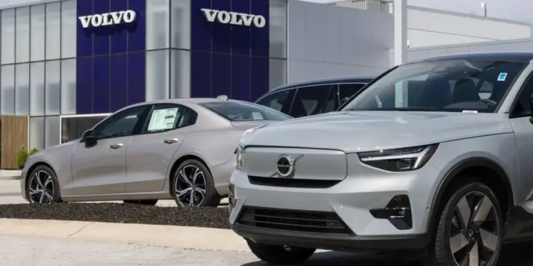 Vista frontal de un concesionario Volvo con dos autos modernos de color gris plateado estacionados afuera. Uno es un sedán y el otro es un SUV.