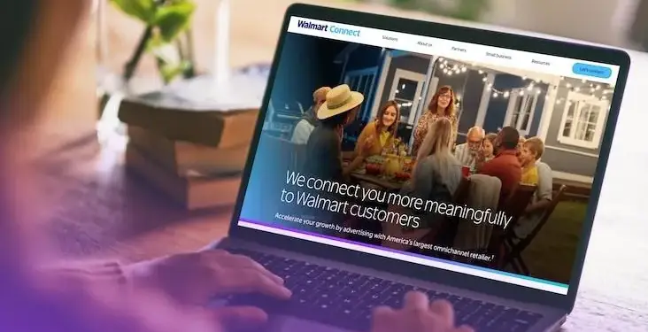 Persona usando un portátil con el sitio web 'Walmart Connect' visible, mostrando una imagen de personas cenando y texto sobre publicidad para clientes.
