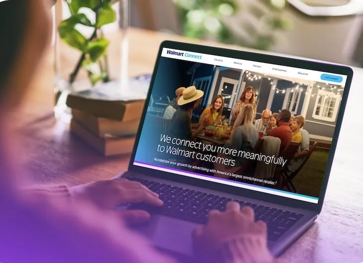 Persona usando un portátil con el sitio web 'Walmart Connect' visible, mostrando una imagen de personas cenando y texto sobre publicidad para clientes.